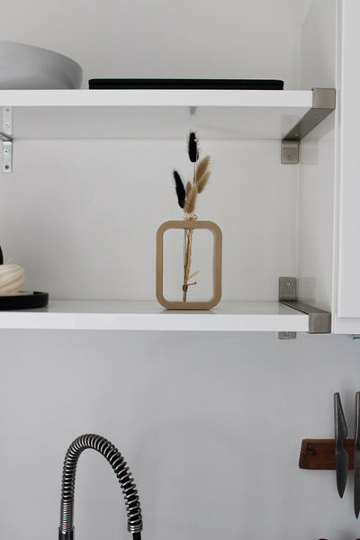 A charming beige mini vase, meticulously crafted by hand. The vase stands at a petite height, showcasing the artistry and attention to detail put into its creation. Its smooth surface boasts a warm beige finish, exuding a sense of elegance and tranquility. The compact size of the vase makes it perfect for showcasing a single delicate flower or a small floral arrangement. The organic curves and gentle contours of the vase add a touch of grace to any space, making it an exquisite addition to your home decor.